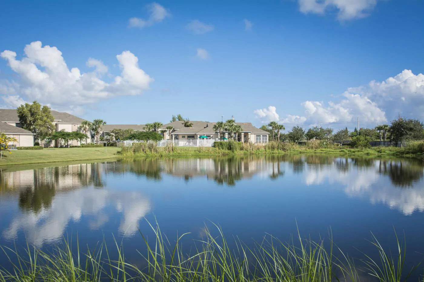 Lake and apartment community under a blue sky