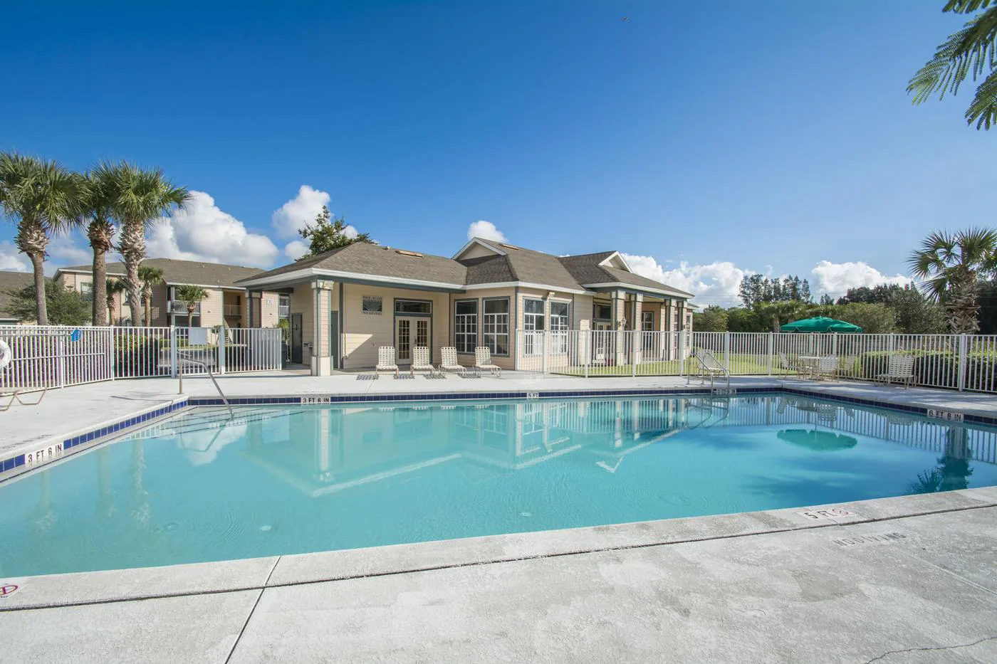 Outdoor pool and clubhouse at Indian River Apartments